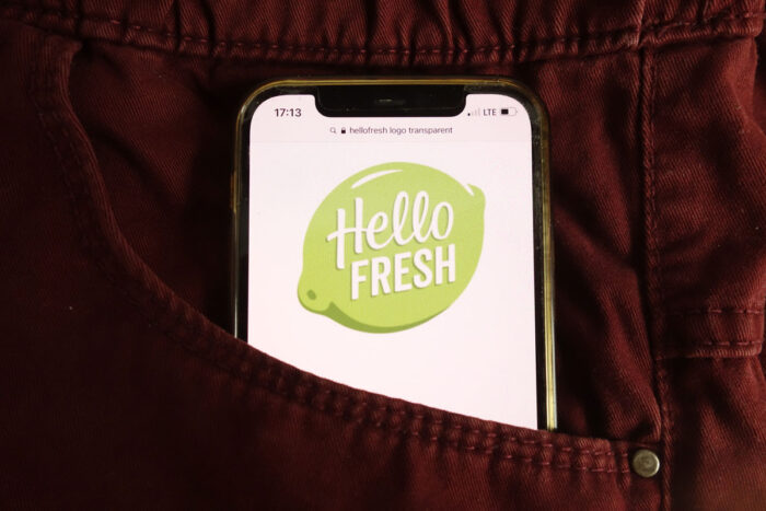 Close up of smartphone in pant pocket with Hello Fresh logo displayed on screen.