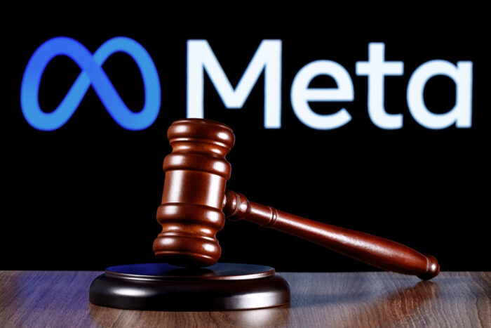 Gavel on table against the background of Meta company logo.