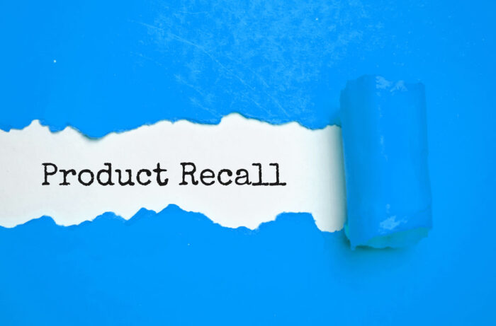 Text Product Recall appearing behind ripped blue paper.