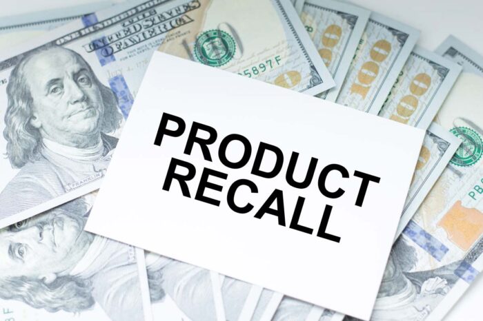 Product Recall inscription on the card on the background of dollar bills - top recalls