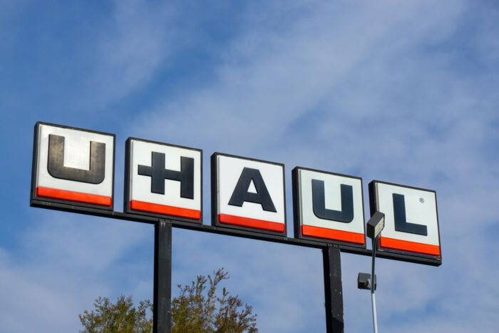 Close up of large U-Haul signage against a blue sky.