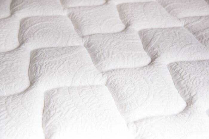 Close up of a pattern on a white mattress.