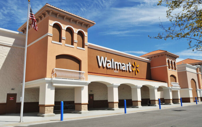 Exterior of a Walmart store against a bright blue sky.