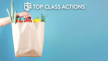 Hand holding paper bag with vegetables empty space blue background.