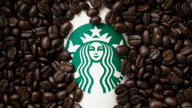 A cup of Starbuck coffee with coffee beans background.