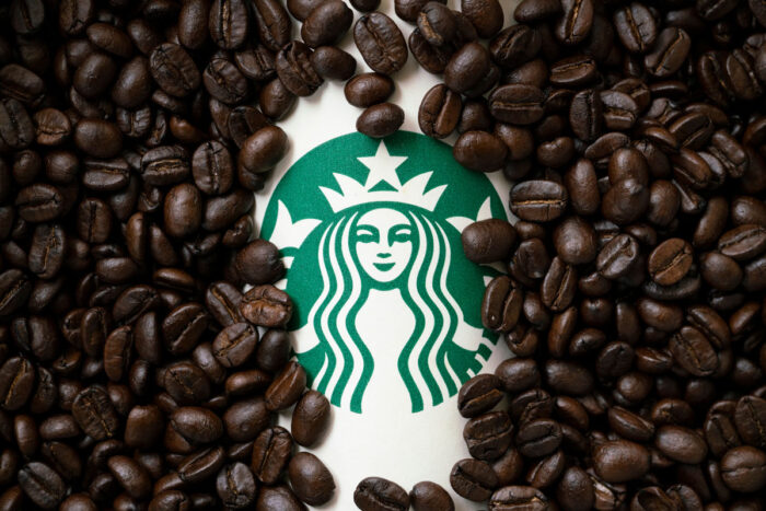 A cup of Starbuck coffee with coffee beans background - Starbucks lawsuit