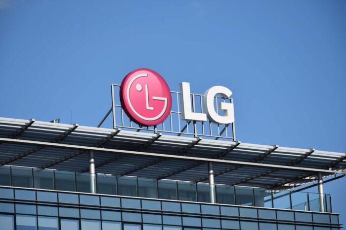 Close up of LG signage on rooftop of building against a blue sky.