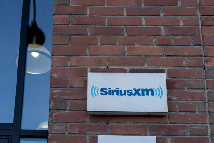 Sirius XM sign on a brick wall.