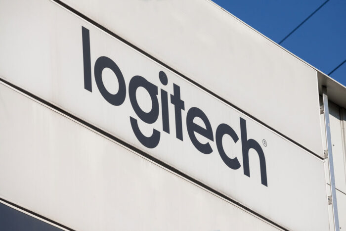 Close up of Logitech signage on exterior of building against a blue sky.