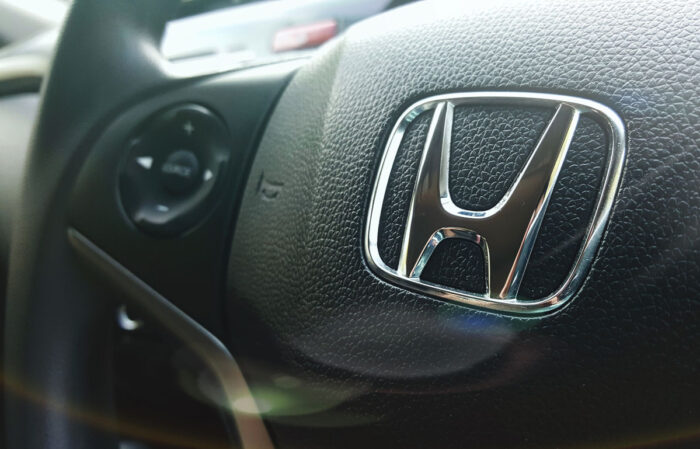 Close up of Honda emblem on a steering wheel - class action