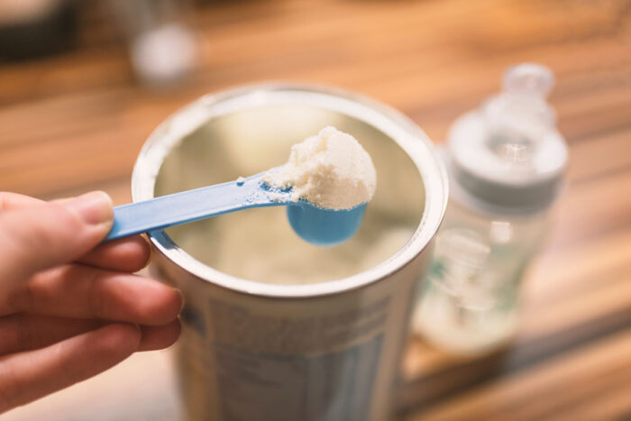 Powder milk and blue spoon on wood background close-up - similac class action settlement
