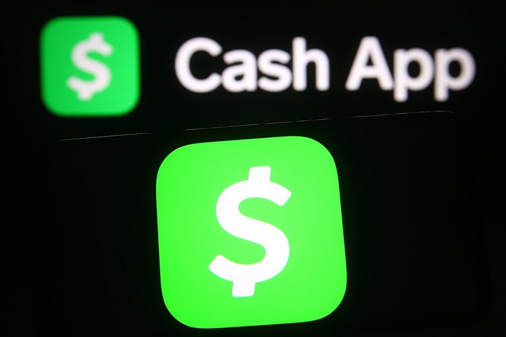 Mobile payment service Cash App logo seen on mobile phone and computer screen.