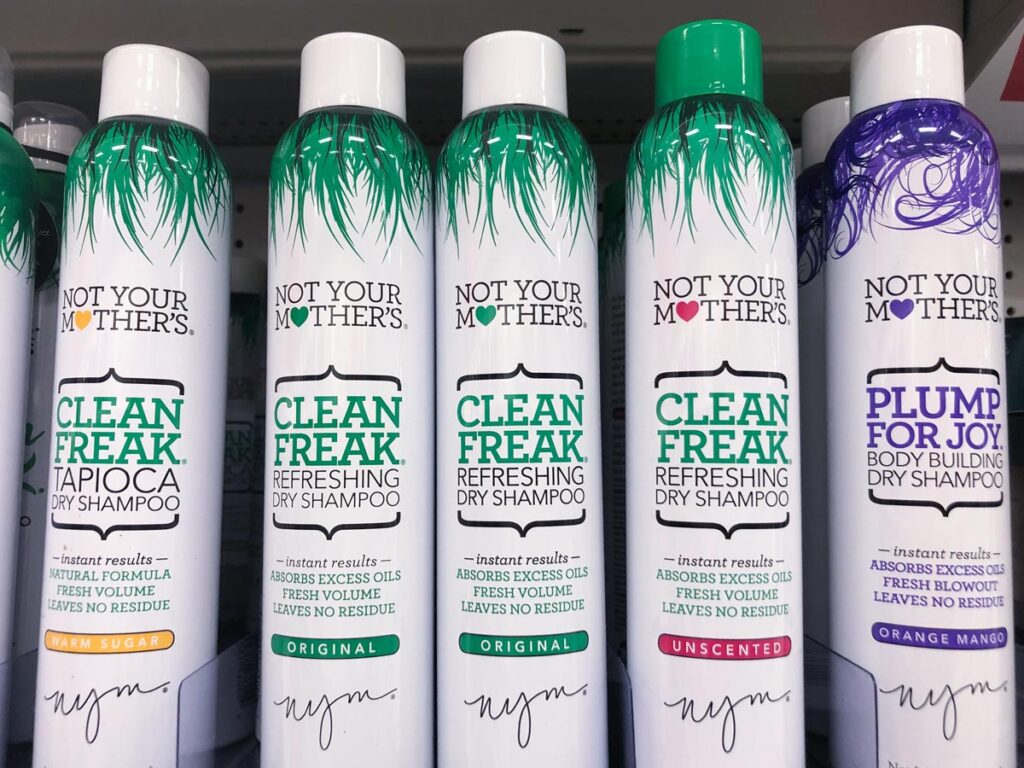 Retail display in the hair care aisle of Not Your Mothers Clean Freak Dry Shampoo bottles.