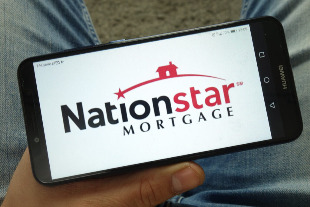 Man holding smartphone with Nationstar Mortgage Holdings Inc. logo displayed on screen.
