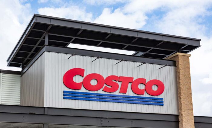 Close up of Costco signage against a blue sky.