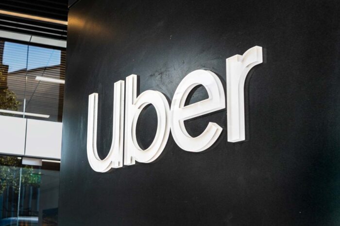 Close up of the Uber logo on a black wall, representing the Uber ADA discrimination class action settlement.