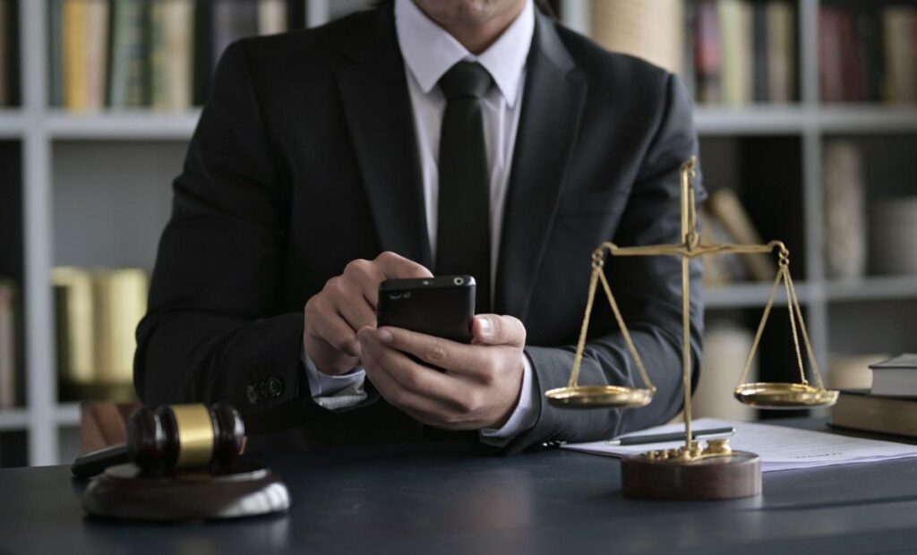 Close up of an attorney using a smartphone in a law office, representing the Howard Law TCPA telemarketing settlement.