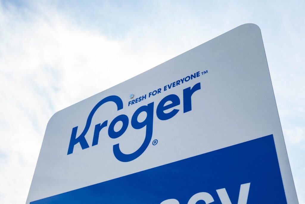 Close up of Kroger signage against a blue sky.
