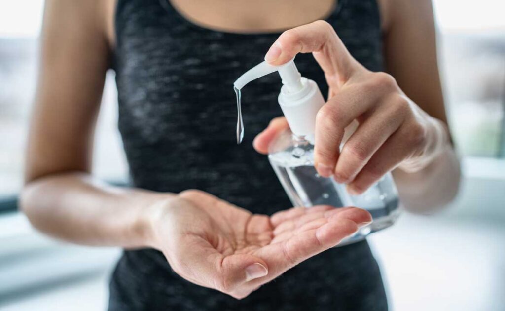Close up of woman apply hand sanitizer to her hands.