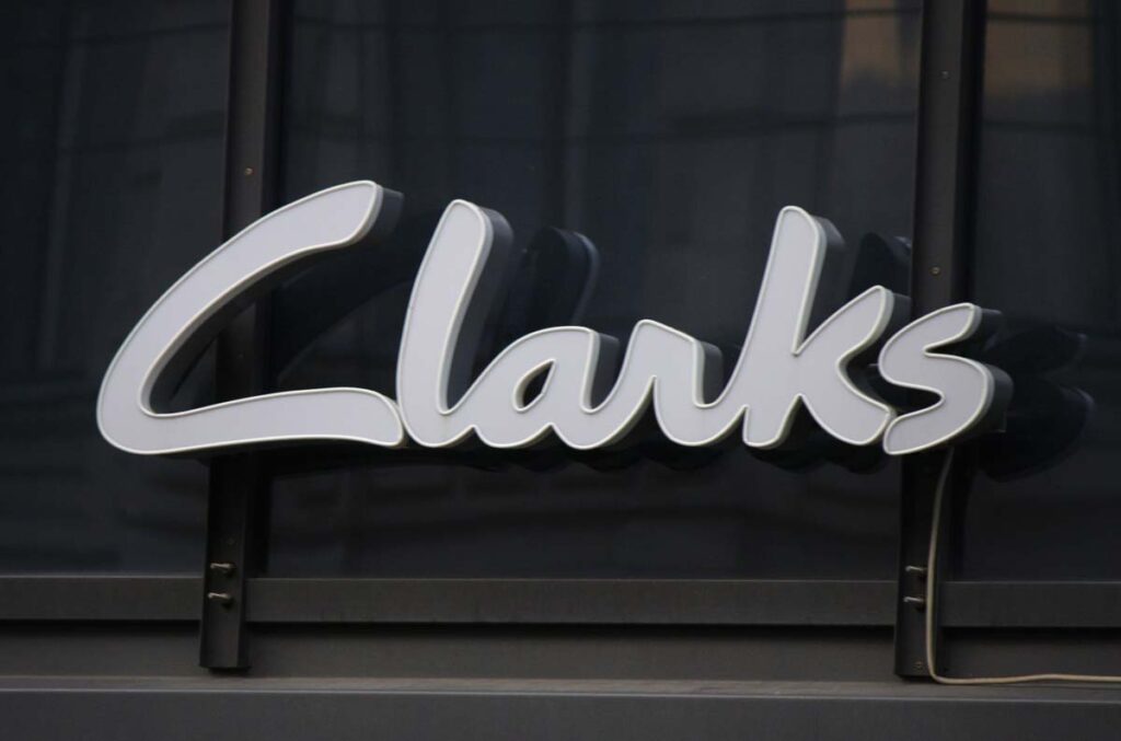 Close up of Clarks signage against a black wall.