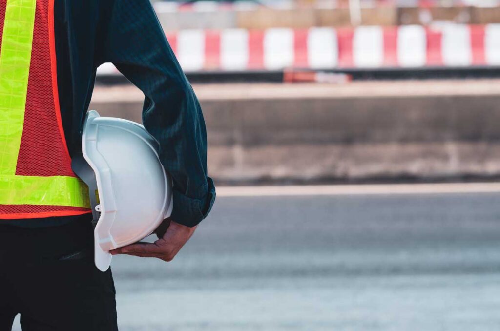 Close up of an inspector holding a white hard hat, representing the Storm Water Inspection & Maintenance Services, or SWIMS, class action settlement.