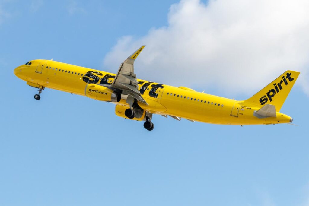 An Spirit Airlines Airbus A321 taking off into the blue sky.