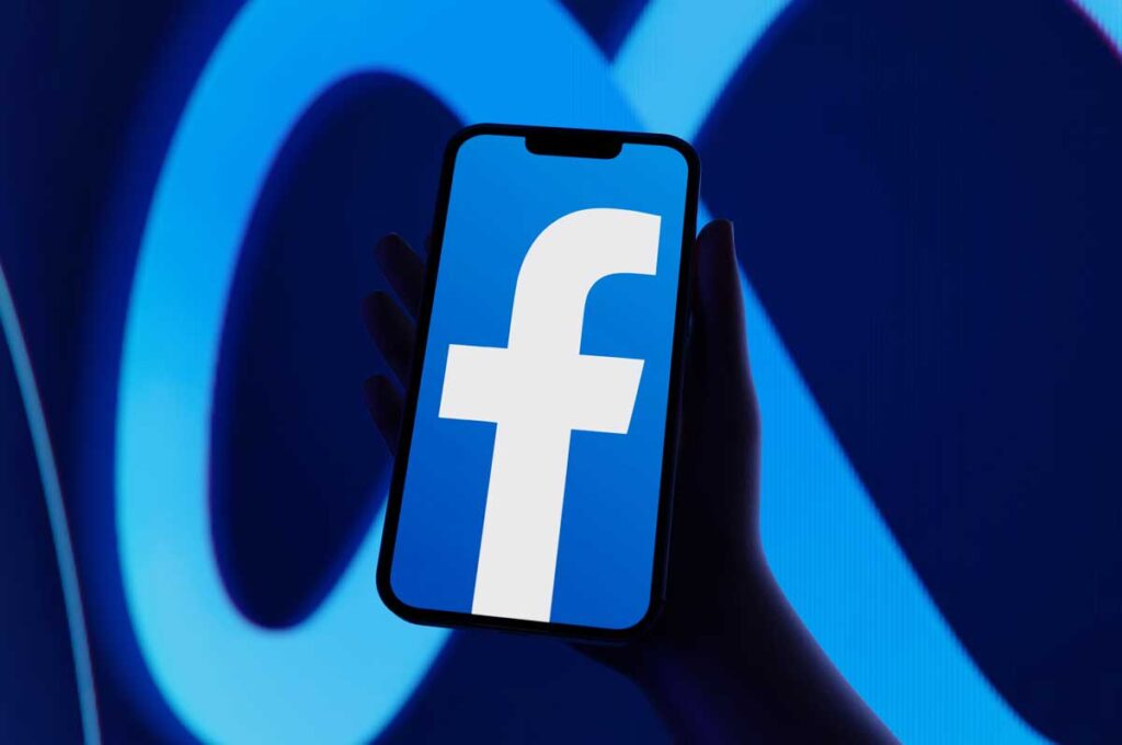 Close up of Facebook logo on a smartphone with the Meta logo in the background, representing the Meta class action.
