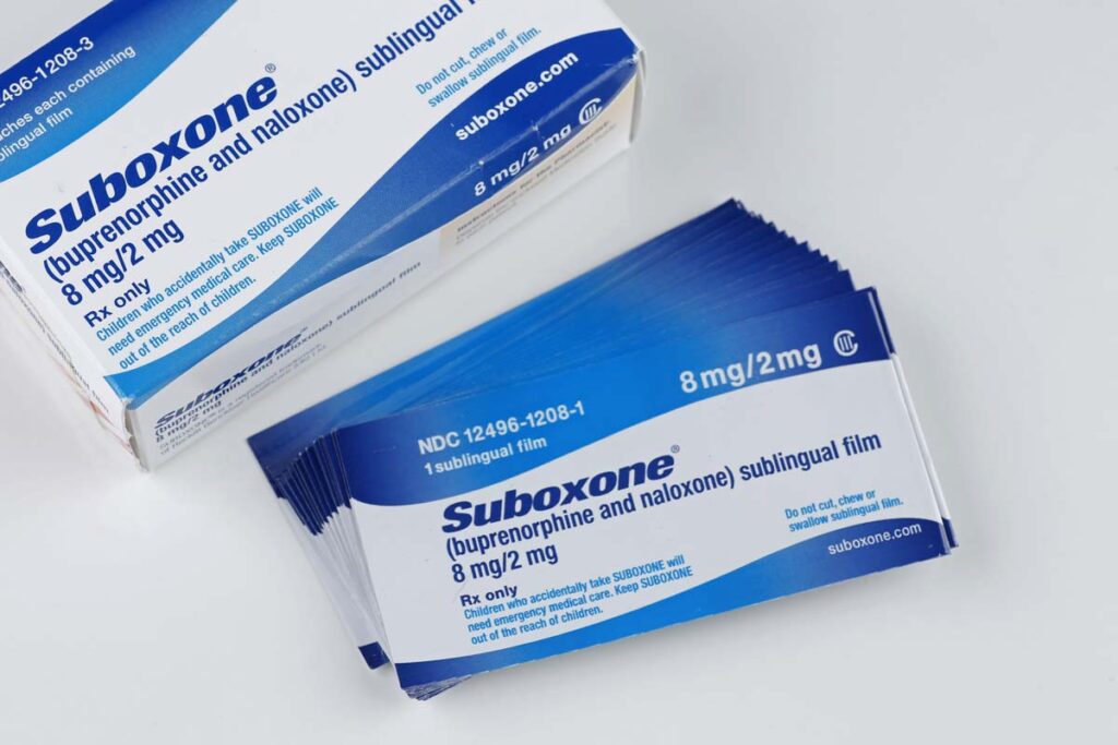 Close up of Suboxone strip packaging next to a larger Suboxone packaging box, representing the Suboxone FTC settlement.