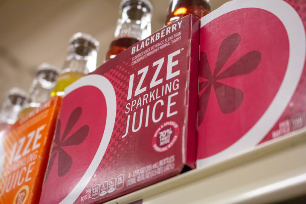 A pack of Izze Sparkling Juice on a shelf at the grocery store.