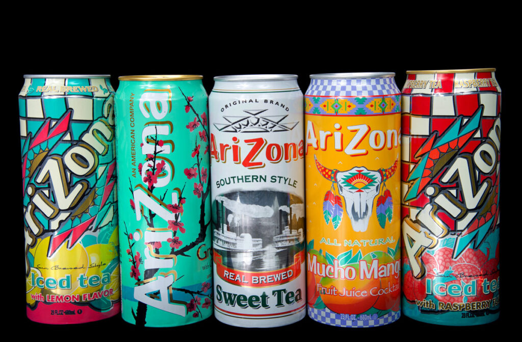 Cans of Arizona brand ice teas in various flavors isolated against a black background.