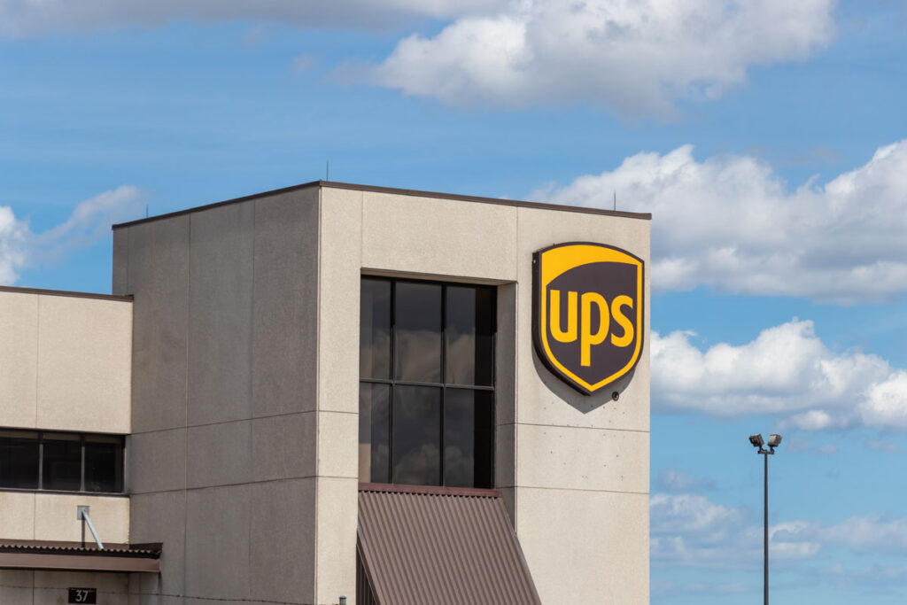 Close up of UPS signage on the exterior of a building against a blue sky.