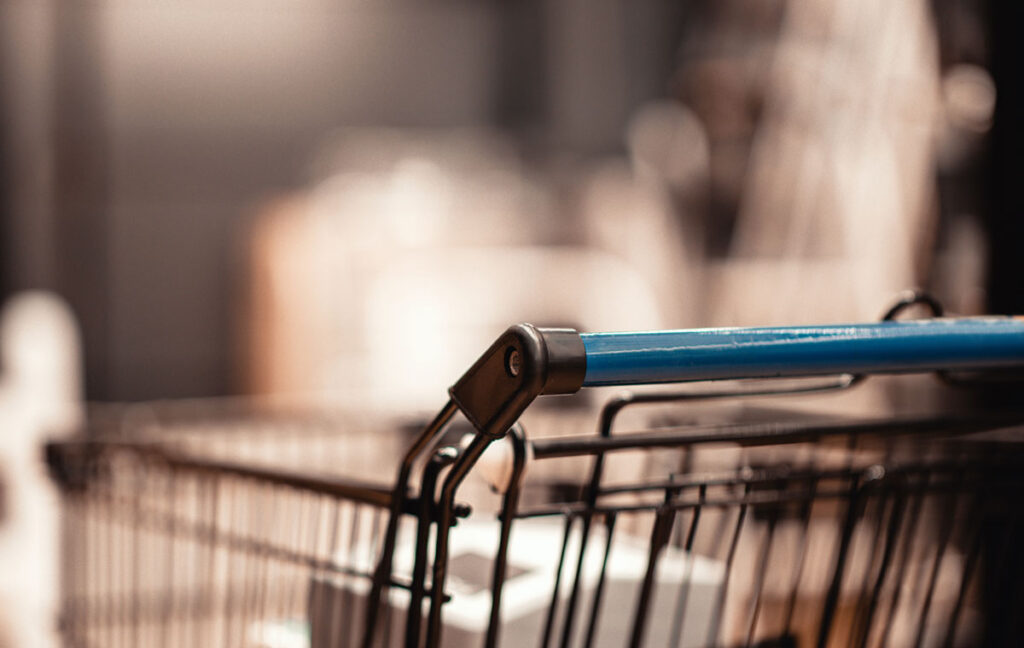 Close up of a shopping cart against a blurry background.