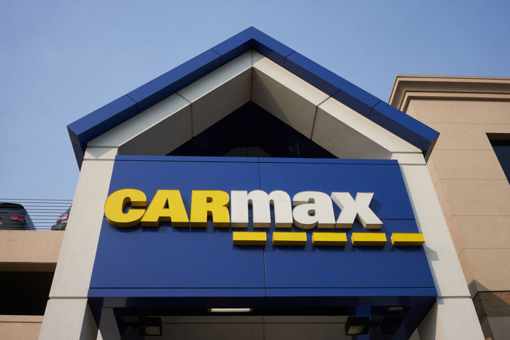 Close up of the CarMax sign seen at the CarMax Store against a blue sky.