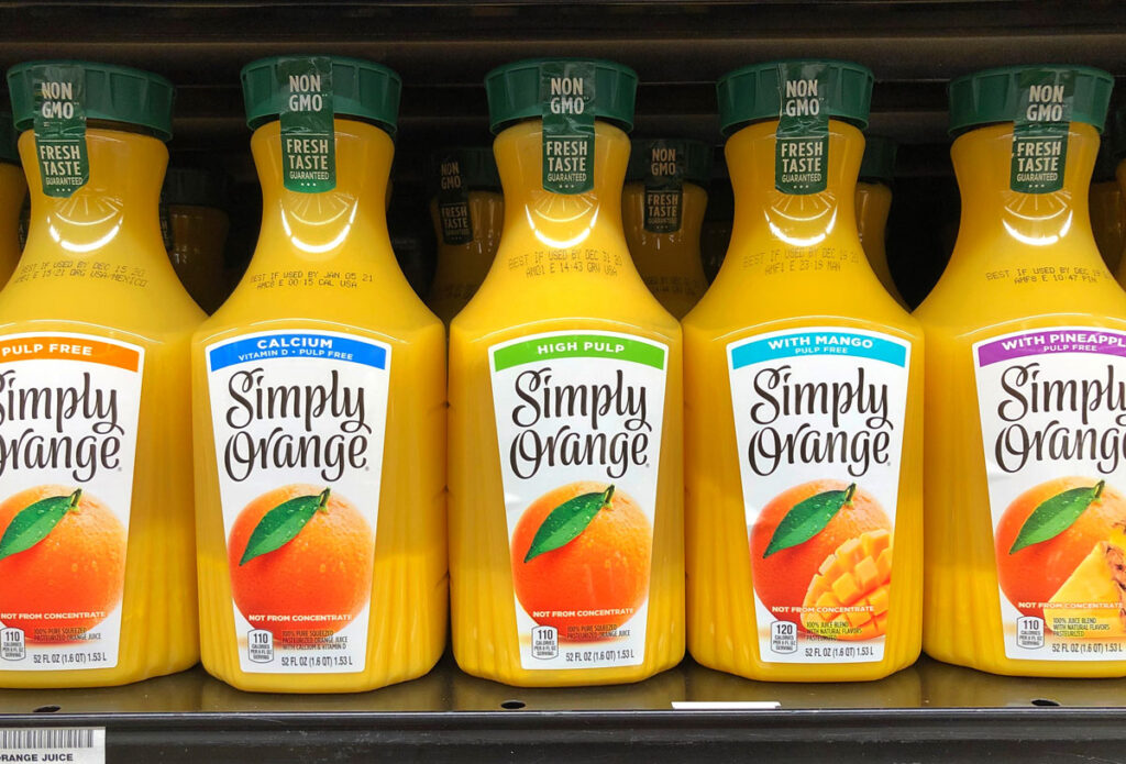 Simply Orange bottles for sale on a grocery store shelf, representing the Coca-Cola and Simply Orange juice PFAS class action.