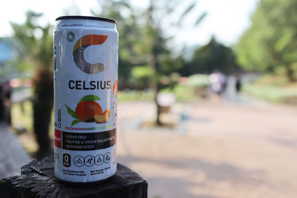 An isotonic drink brand Celsius with peach flavor in blurry background, representing the Celsius class action settlement.