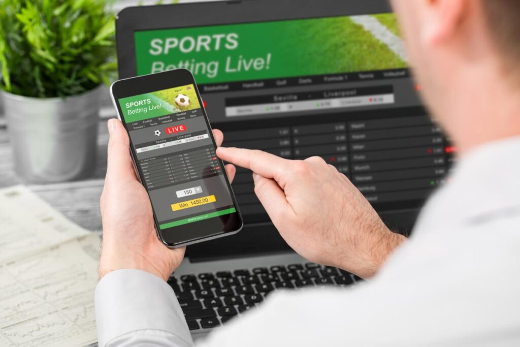 Close up of a man betting on sports on his smartphone.