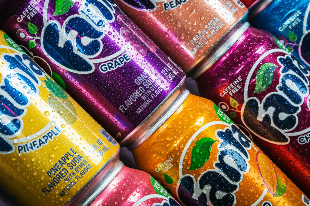 Close up of Fanta cans in various flavors covered in water droplets pina colada fanta, coca-cola class action