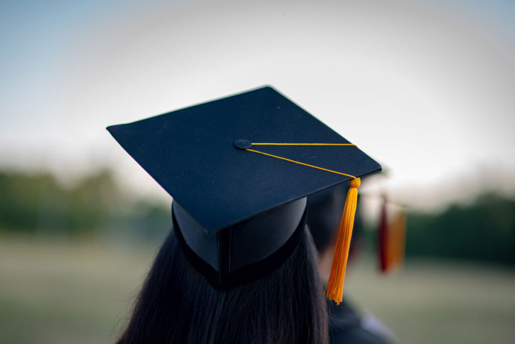 Close up back view of a girl wearing a graduation cap - Notre Dame College website class action