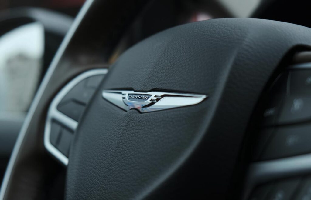 Close up of Chrysler emblem on a steering wheel, representing the Chrysler Pacifica recall.