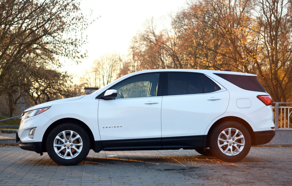 2017 Chevrolet Equinox SUV in white against foilage.