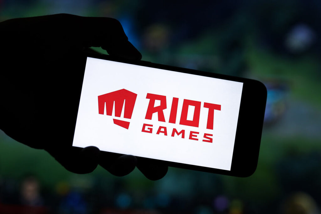 Close up of Riot games logo displayed on a smartphone screen.