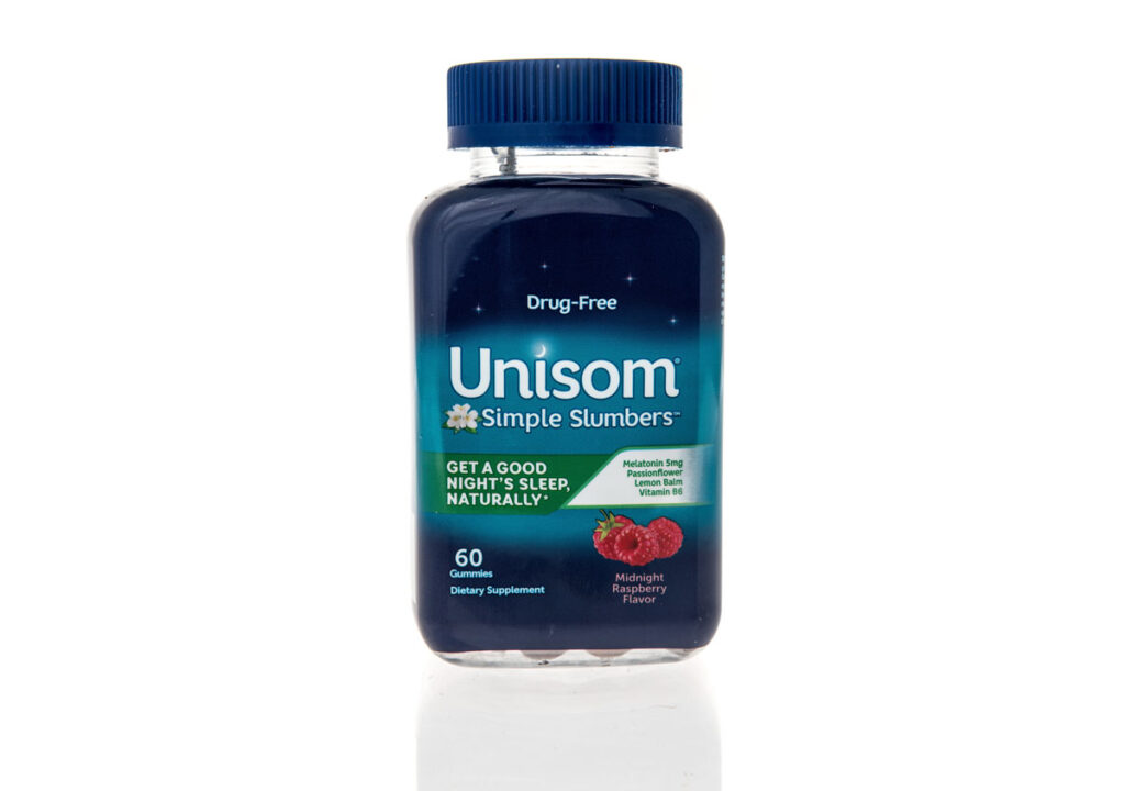 A bottle of Unisom simple slumbers sleep aid supplement with melatonin on an isolated background.