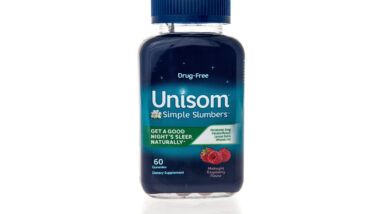 A bottle of Unisom simple slumbers sleep aid supplement with melatonin on an isolated background.