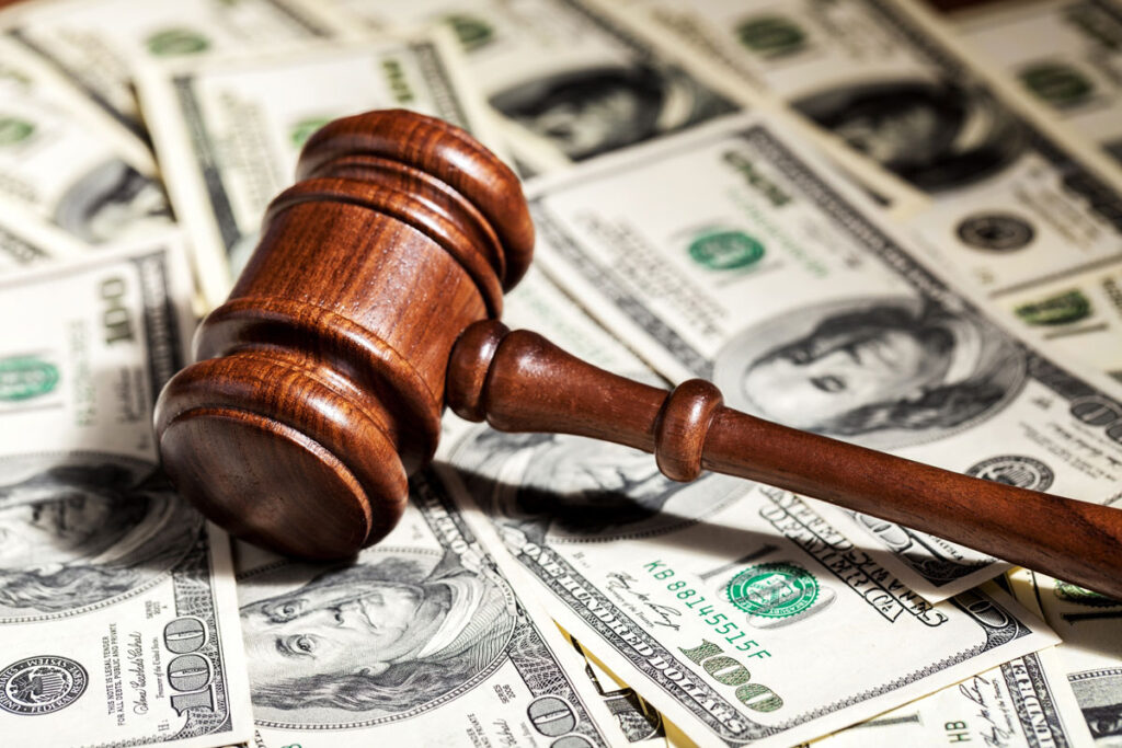 Close up of a wooden gavel on top of cash.