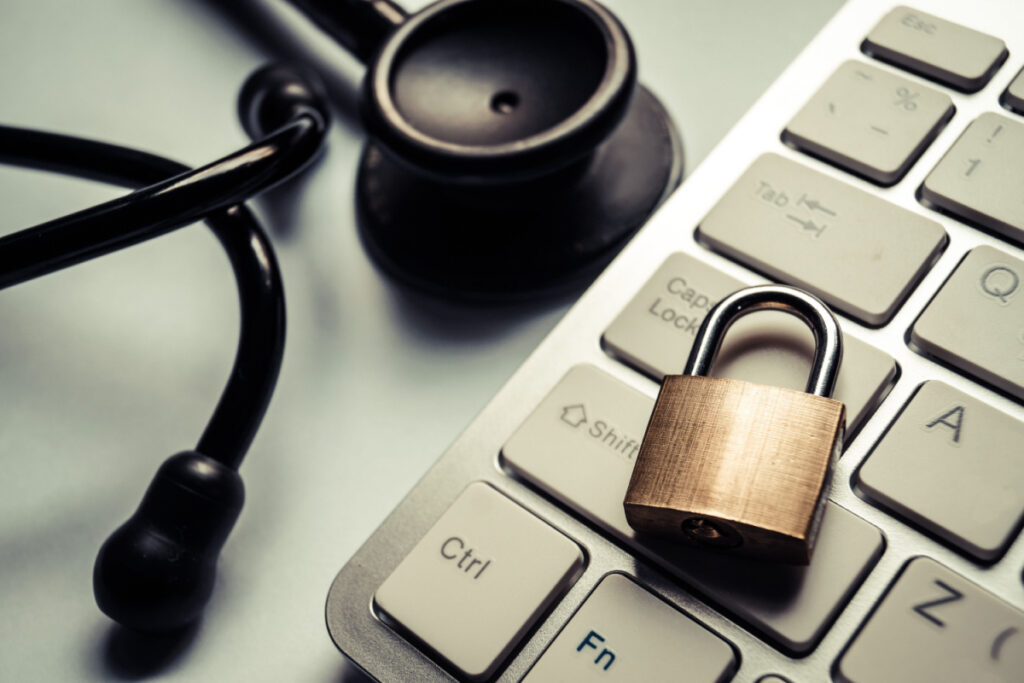 A lock lies on a computer keyboard next to a stethoscope, representing the True health new Mexico data breach class action settlement.