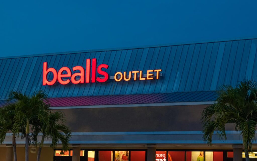 A Bealls Outlet storefront image taken during twilight hours as seen from the parking lot.