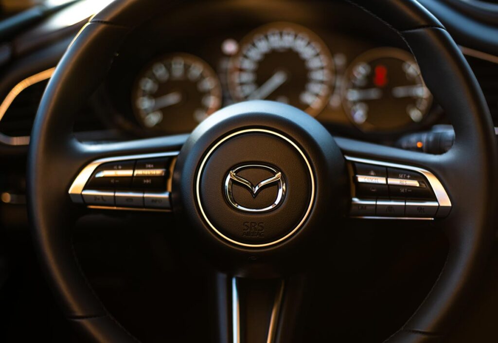 Close up of Mazda steering wheel, representing the Mazda oil leakage class action lawsuit.