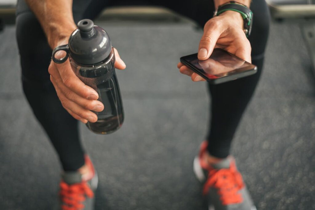 Close up of an athletes hands using a smartphone before a workout.