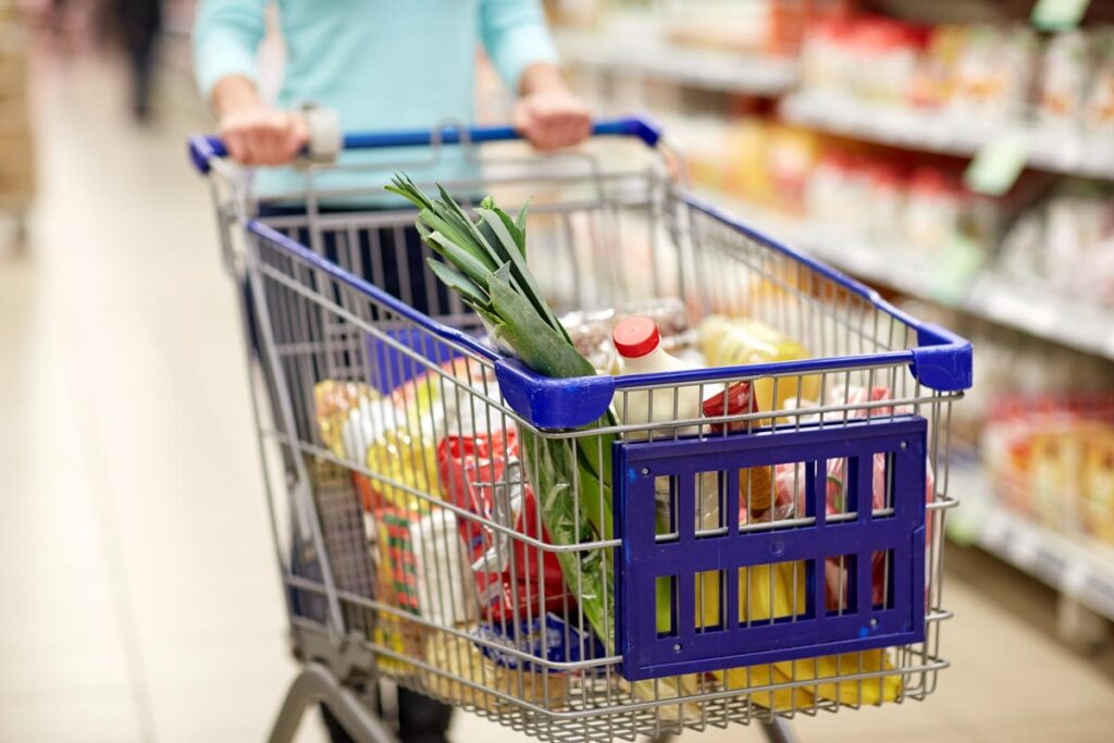 Close up of various foods in a shopping cart.