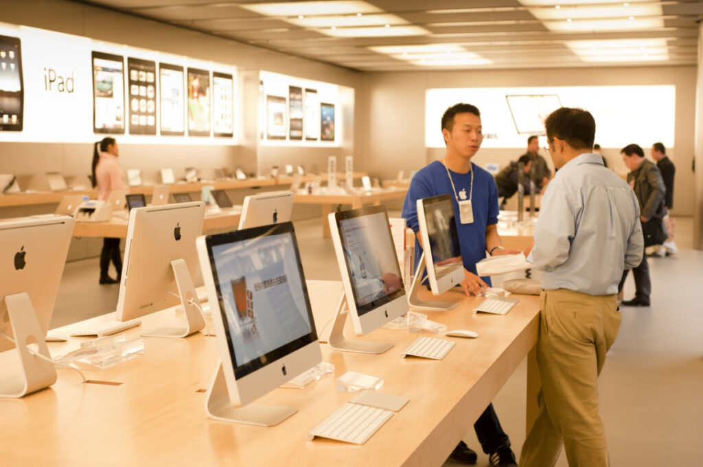 Apple employee helping customer in Apple Store.